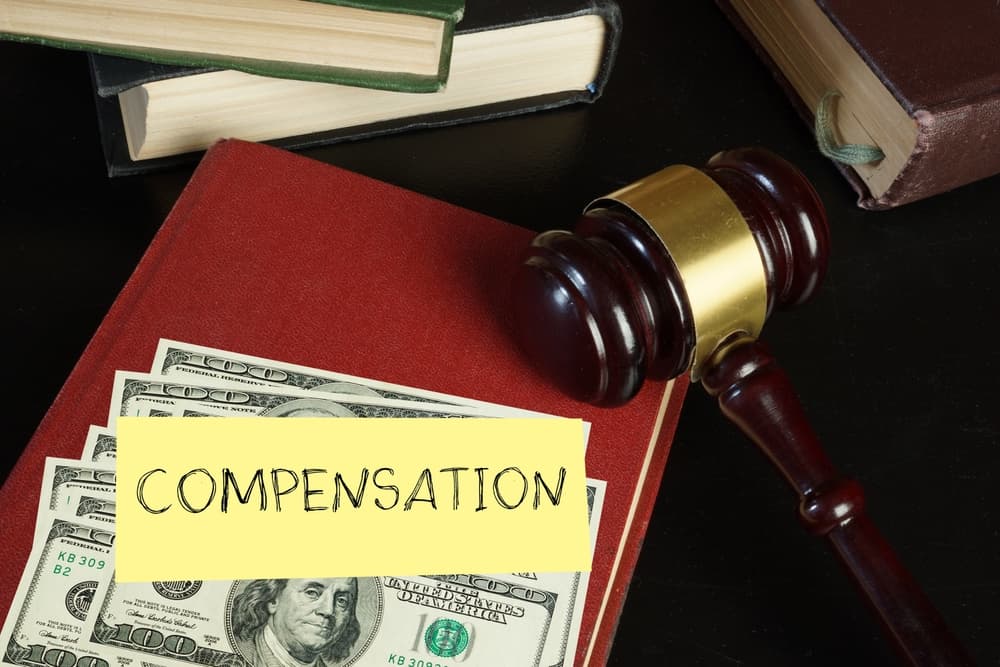 Compensation and judge's gavel. Moral financial compensation for caused damage.